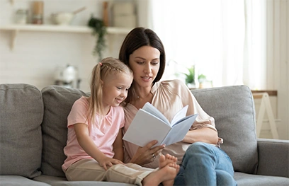 [:en]Nanny liest ein Buch zusammen mit einem Mädchen[:]